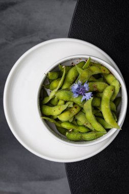 Beyaz tabakta yeşil bezelye lokantası.