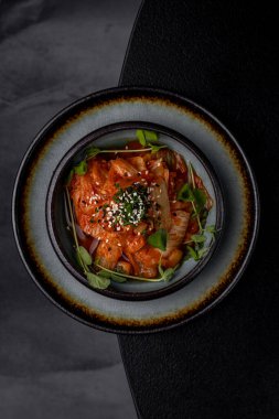 Lokantada tabakta lahana turşusu, karanlık bir arka plan.