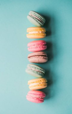 Üst görünüm mavi arkaplandaki renkli badem kurabiyelerini kapat.