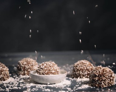 Kurutulmuş hindistan cevizi serpiştirilmiş bir masaya İsveç koosbullar topları serpiştirilmiş.