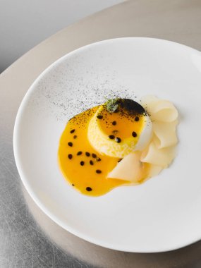 Beyaz bir tabakta servis edilen eşsiz bir tatlı soslu ve garnitürlü.