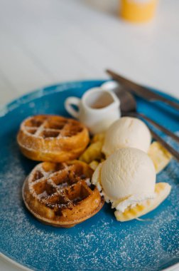Vanilyalı Waffle dondurması ve Cafe 'de mavi tabakta şurup.