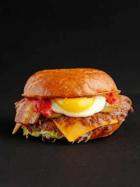 Siyah arka planda büyük bir burger.