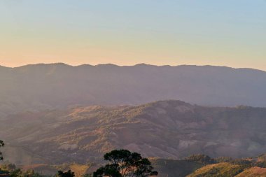 Günbatımında tropikal dağdaki sıcak güneş ışığının manzarası