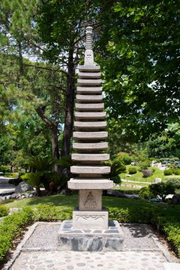 Yeşil ağaçlarla çevrili taş tapınak.