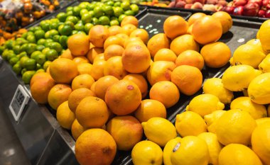 Marketteki raflardaki limonları, portakalları ve limonları kapat..