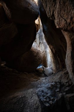 Dağınık ışık ve engebeli dokularıyla gölgeli kaya mağarası geçidi
