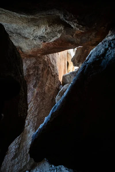 Çöl mağarası geçidinde dar kaya çatlaklarından bakan ışık.