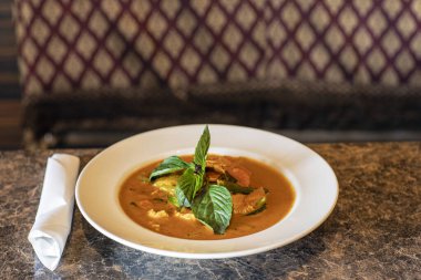 Bir kase köri ve taze fesleğen yaprağı.