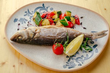 Sebze tabağında kızarmış levrek.