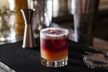 Barın tepesinde kırmızı portakallı içecek ve aksesuarlar.