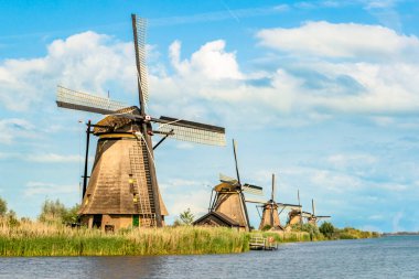 Kinderdijk 'te gün batımında kanalda bir dizi tarihi rüzgar değirmeni.