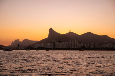Okyanustan İsa 'ya, Kurtarıcı' ya ve Brezilya 'nın Rio de Janeiro kentindeki diğer dağlara güzel bir gün batımı manzarası.