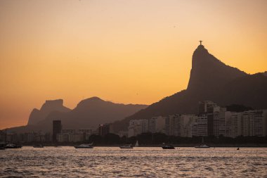 Okyanustan İsa 'ya, Kurtarıcı' ya ve Brezilya 'nın Rio de Janeiro kentindeki diğer dağlara güzel bir gün batımı manzarası.