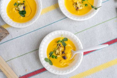 Masa örtüsü üzerinde sarı karnabahar püresi kaseleri