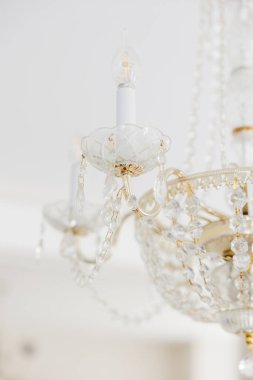 Kristal avize zarif bebek partisi dekorunu aydınlatıyor.