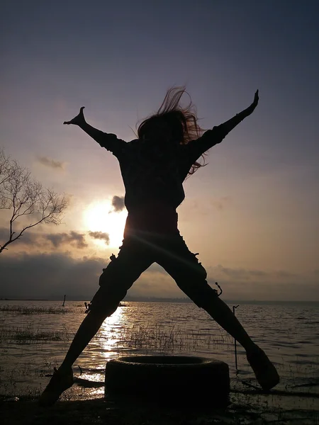 점프 하는 젊은 여자의 실루엣. — 스톡 사진