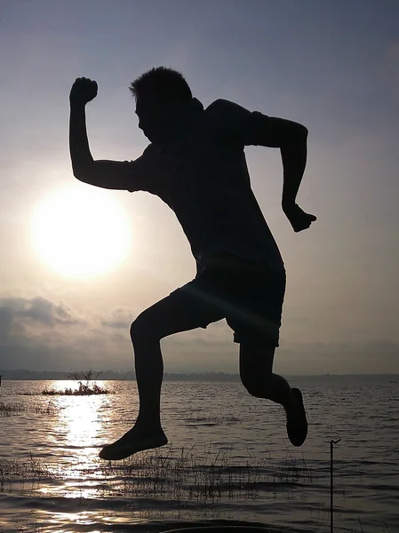 Silhouette of young man jumping. — Stock Photo, Image