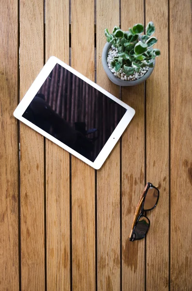 Tablette vierge sur bureau en bois avec lunettes de soleil — Photo
