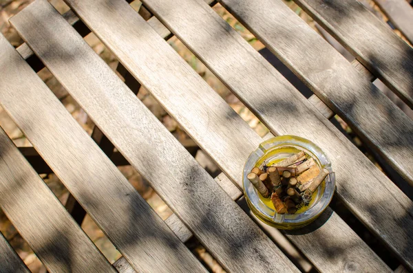 木製のテーブルの上のタバコの吸い殻 — ストック写真