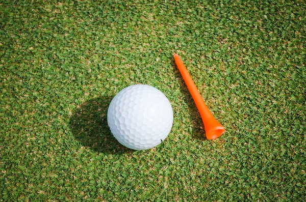 Golfboll med orange t-shirt på gröna — Stockfoto