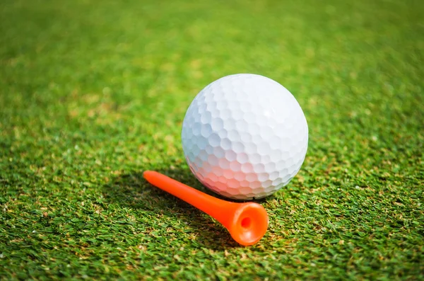 Golfboll på orange tee — Stockfoto