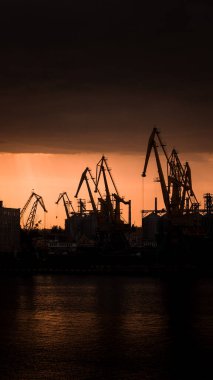 Günbatımında rıhtımda vinçler