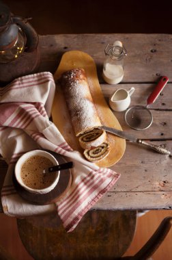 Lezzetli kek rulosu ve eski ahşap masada kahve. Kırsal biçim