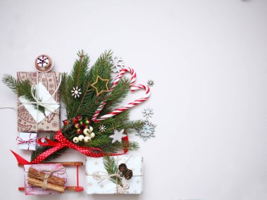 Beyaz arka planda yeni yıl ve noel kompozisyonu. Hediyeler, tatlılar ve ağaç süslemeleri. Yukarıdan manzara.