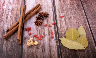 Organik baharat, tarçın, kakule, defne yaprağı, ahşap arka planda yıldız anason karışımı egzotik bitkiler. 