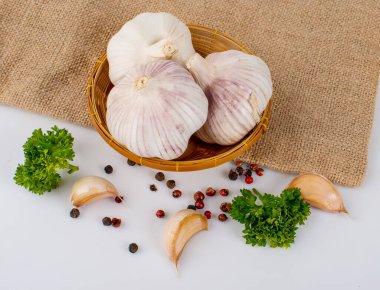 Sacks arka planında sarımsak, biber ve maydanoz.