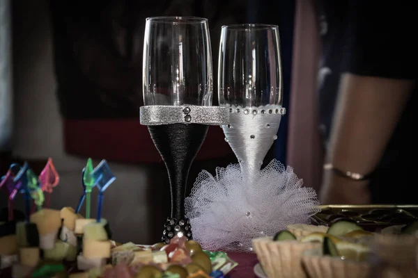 Dois copos de vinho lindamente decorados na mesa festiva. Preto e branco — Fotografia de Stock