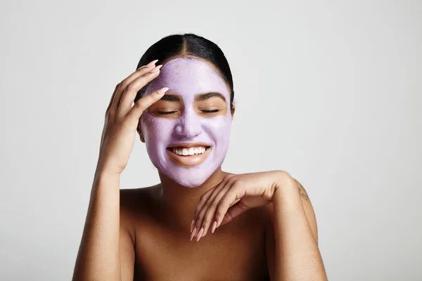 Mujer con máscara facial púrpura — Foto de Stock
