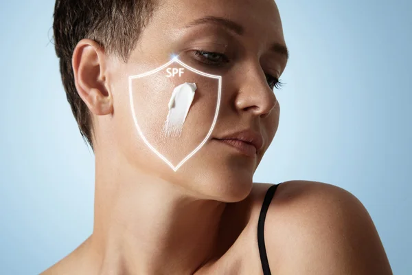 Woman with cream on cheek — Stock Photo, Image