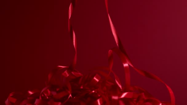 Купка червоних шовкових блискучих смуг падає на матовий червоний фон. 4k якість все ще горизонтальні кадри дробу . — стокове відео