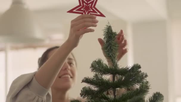 Brunette Kaukasische jonge vrouw maken en kunstmatige kerstboom. Medium shot 4k videobeelden van hoge kwaliteit. — Stockvideo