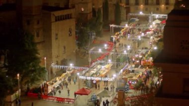 Avrupa 'daki bir Noel pazarında aşağı bakış. İspanya 'nın Barselona şehrinde sokak lambaları. 4k yüksek kaliteli video kaydı.
