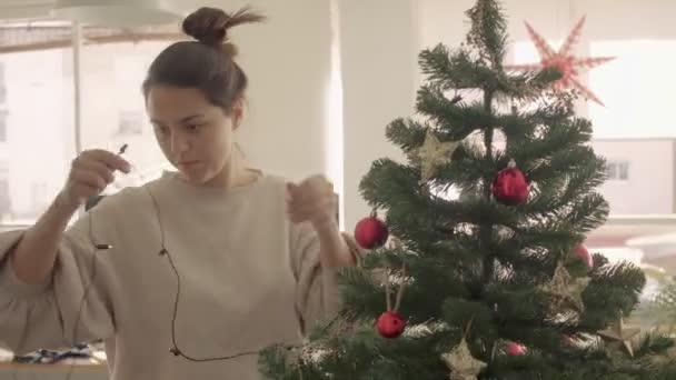 घर पर काले बाल मिश्रित दौड़ महिला सजावट और कृत्रिम क्रिसमस पेड़। मध्यम वाइड कैमरा शॉट 4k उच्च गुणवत्ता वीडियो फुटेज . — स्टॉक वीडियो