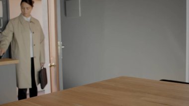 Ofis çalışanı eve gelir ve ön kapıdan girer. Yüksek kalite görüntü yüksek çözünürlüklü jpg resmi.