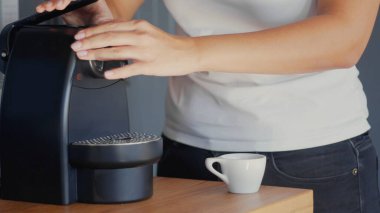 Beyaz kadınlar Nespresso kahve makinesine özel kapsüllü kahve yüklüyorlar. Yüksek kaliteli jpg fotoğrafı