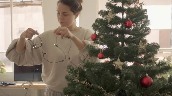 Beyaz tenli genç bayan dekorasyonu ve evde yapay Noel ağacı. Orta Geniş Kamera yüksek kaliteli jpg görüntüsü. Telifsiz Stok Imajlar