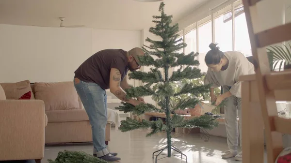 Família em casa formando uma árvore de Natal artificial. Imagem de foto de alta resolução de nível de quadril completo Imagens De Bancos De Imagens Sem Royalties