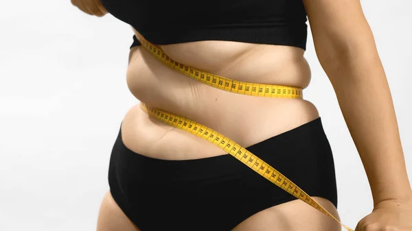 Excess weight caucasian woman wrap measure tape around her waist. Shot high quality photo image. — Stock Photo, Image
