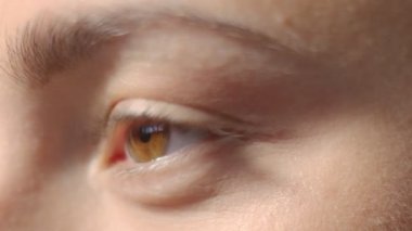 Beyaz kızların gözleri dışarı bakıyor ve kameraya bakıyor. Makro yakın plan gözler yanıp sönüyor. Yavaş Hareket yüksek kaliteli video. 