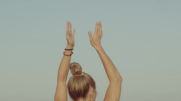 Blonďatá mladá běloška cvičí jógu na útesu před mořem nebo oceánem. Zpět pohled podstavec zpomalení film vysoce kvalitní video záběry. — Stock video