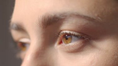 Beyaz kızların gözleri dışarı bakıyor ve kameraya bakıyor. Makro yakın plan gözler yanıp sönüyor. Yavaş Hareket yüksek kaliteli video. 