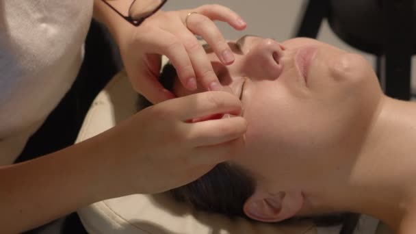 美容师抬起睫毛并将其绑在硅胶垫上进行叠层处理。侧视图高质量的视频镜头. — 图库视频影像