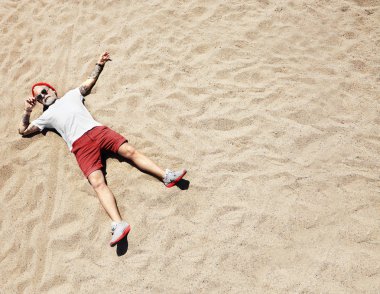 Man lying down on beach clipart