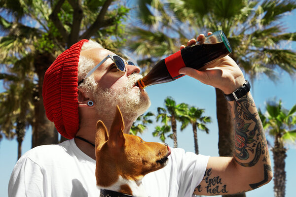 Man drinking fizzy water with dog