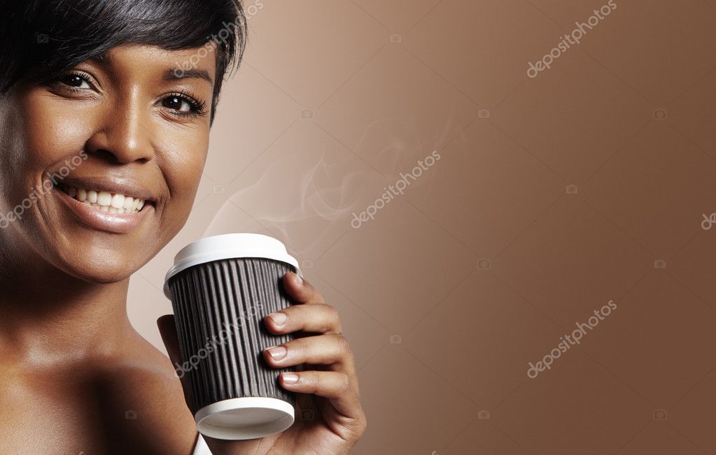 Happy black woman holding hot coffee in paper cup on brown background